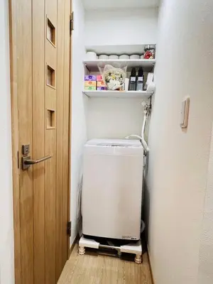 a washer and dryer in a bathroom with a door at Kameido Wisteria Retreat 2 Floor in Tokyo