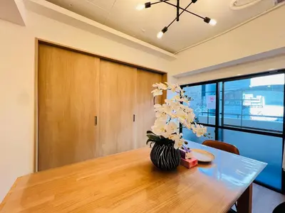 a dining room table with a vase of flowers on it at Kameido Wisteria Retreat 2 Floor in Tokyo