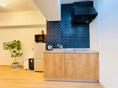 a kitchen with a sink and a blue brick wall at Kameido Wisteria Retreat 2 Floor in Tokyo