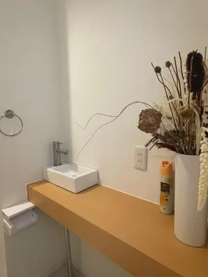 a bathroom counter with a sink and a vase with flowers at Kameido Wisteria Retreat 6 Floor in Tokyo