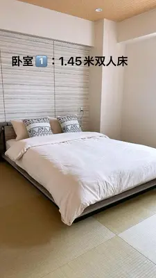 a bedroom with a large white bed with a wall at Kameido Wisteria Retreat 6 Floor in Tokyo