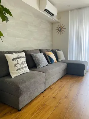 a living room with a gray couch with pillows at Kameido Wisteria Retreat 7 Floor in Tokyo
