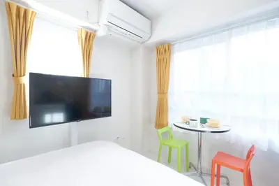 a bedroom with a bed and a table with chairs at Rio Grande Nishi-Shinjuku by Tranova in Tokyo