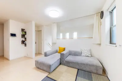 a living room with a gray couch and a window at Jin's Place - 15m to Haneda & Shinagawa in Tokyo