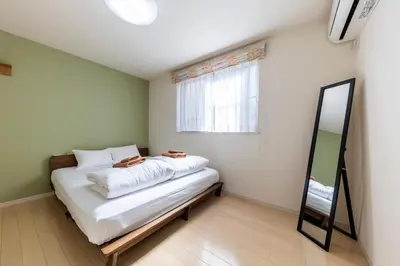 a small bedroom with a bed and a mirror at Jin's Place - 15m to Haneda & Shinagawa in Tokyo
