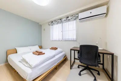 a bedroom with a bed and a desk and a chair at Jin's Place - 15m to Haneda & Shinagawa in Tokyo