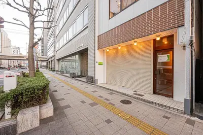 a building with a garage door on the side of a street at Mori hotel AKIHABARA 2 in Tokyo