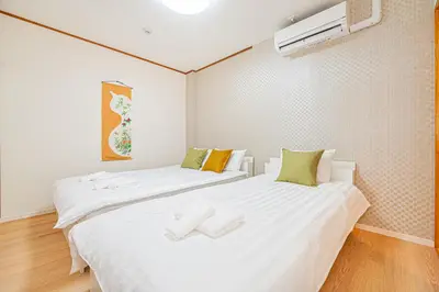 two beds in a small room with white sheets at Mori hotel AKIHABARA 2 in Tokyo