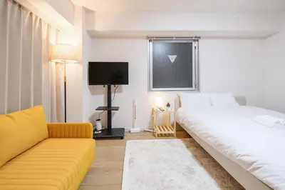 a bedroom with a large bed and a couch at Shinjuku Raise OG House in Tokyo