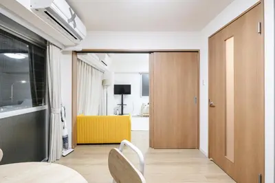 a room with a door and a table and chairs at Shinjuku Raise OG House in Tokyo