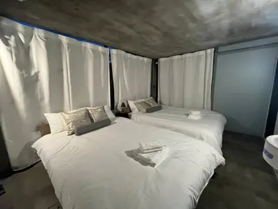 two beds in a room with white sheets at Natsumezaka Room2 NM2 in Tokyo