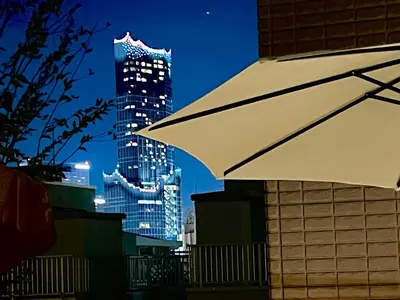 a white umbrella in front of a city at night at Shinjuku\u5927\u4e45\u4fdd3 in Tokyo