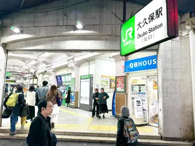 a group of people standing outside of a subway station at Shinjuku\u5927\u4e45\u4fdd3 in Tokyo