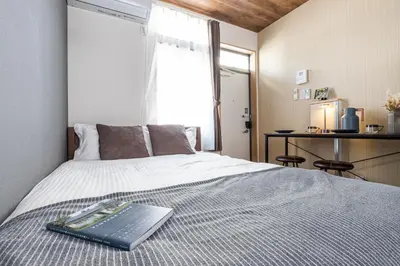 a laptop computer sitting on top of a bed at Cozy Vintage Studio Asakusa Skytree Ueno Akihabara in Tokyo