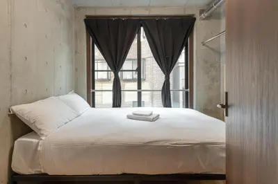 a bedroom with a large bed with a window at \u53f0\u6771\u533a\u53f0\u6771\u3067\u5feb\u9069\u306a\u5bbf\u6cca\u3092\u6d45\u8349 \u4e0a\u91ce\u89b3\u5149\u306e\u62e0\u70b9\u306b 201 in Tokyo
