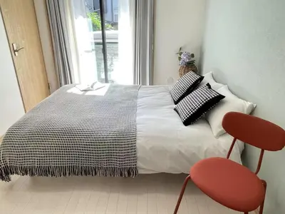 a bedroom with a bed with two red chairs at COMMA HOUSE Kitaikebukuro 101 in Tokyo