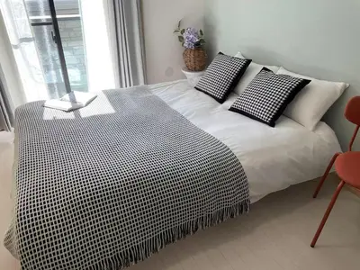 a bedroom with a bed with black and white pillows at COMMA HOUSE Kitaikebukuro 101 in Tokyo