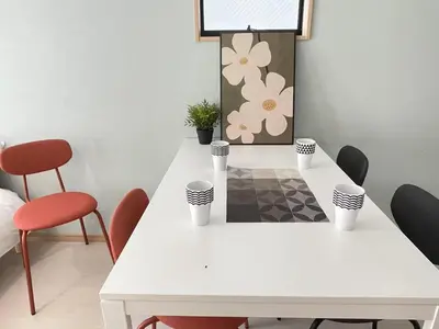 a white dining room table with red chairs and a white table at COMMA HOUSE Kitaikebukuro 101 in Tokyo