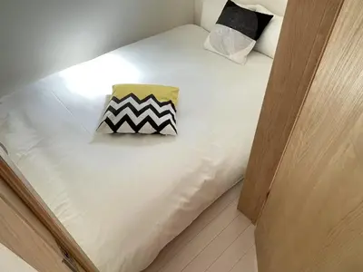 a white bed with a pillow on top of it at COMMA HOUSE Kitaikebukuro 101 in Tokyo