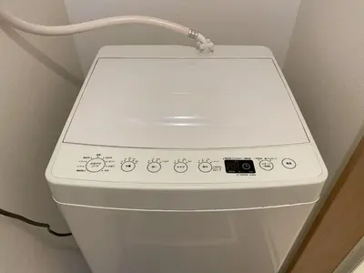 a white toilet in a bathroom with a hose at COMMA HOUSE Kitaikebukuro 101 in Tokyo
