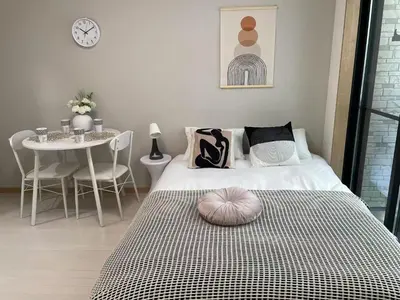 a bedroom with a bed and a table with chairs at COMMA HOUSE Kitaikebukuro 102 in Tokyo