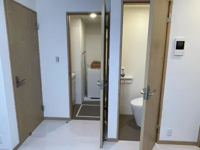 a bathroom with two doors and a toilet at COMMA HOUSE Kitaikebukuro 102 in Tokyo