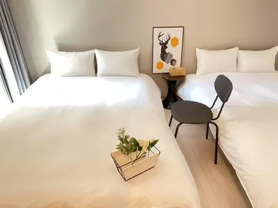 two beds in a hotel room with a plant on the bed at COMMA HOUSE Kitaikebukuro 103 in Tokyo