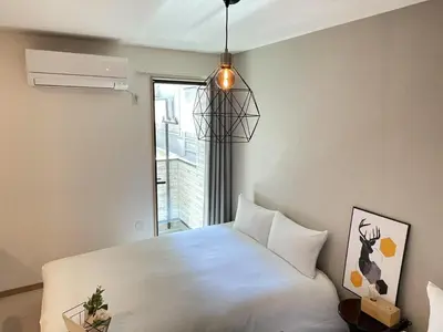 a bedroom with a white bed and a window at COMMA HOUSE Kitaikebukuro 103 in Tokyo