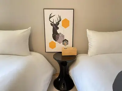 a bedroom with two beds and a table with a deer picture at COMMA HOUSE Kitaikebukuro 103 in Tokyo