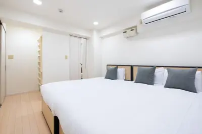 a bedroom with a large white bed with blue pillows at Ms\u30d3\u30ebll in Tokyo