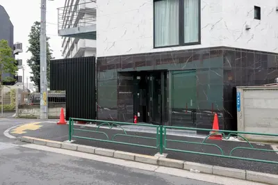 a building with orange cones on the side of a street at \u795e\u6cc9 \u672c\u90e8\u30d3\u30eb in Tokyo