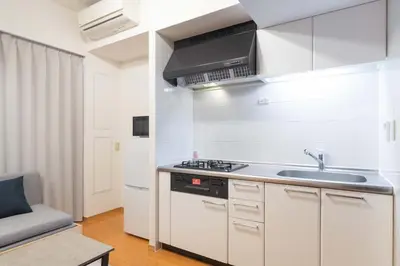a white kitchen with a sink and a stove at Daffitto\u5929\u738b\u6d32 in Tokyo