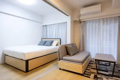 a bedroom with a bed and a chair at \u30eb\u30af\u30ec\u521d\u53f0 in Tokyo