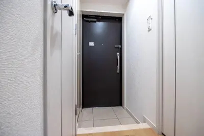 a hallway with a black door and a tile floor at \u30eb\u30af\u30ec\u521d\u53f0 in Tokyo