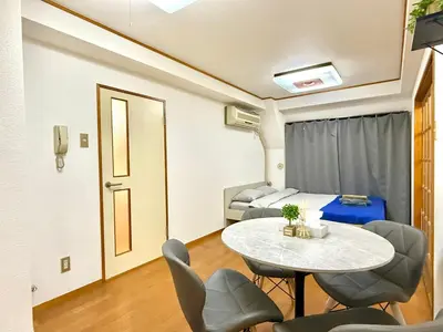 a room with a table and chairs and a bed at Ikebukuro Sugamo\u99c5\u8fd1\u6700\u592710\u4eba\u53ef in Tokyo