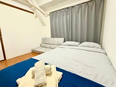 a bedroom with a large white bed and a couch at Ikebukuro Sugamo\u99c5\u8fd1\u6700\u592710\u4eba\u53ef in Tokyo