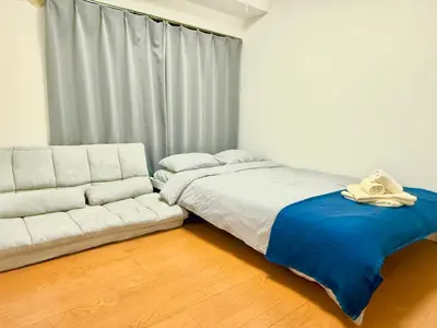 a bedroom with a white bed and a couch at Ikebukuro Sugamo\u99c5\u8fd1\u6700\u592710\u4eba\u53ef in Tokyo