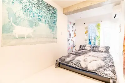 a bedroom with a bed and a painting on the wall at TOKYO SKYTREE Cat house \u62bc\u4e0a\u99c5\u5f92\u6b696\u5206 \u6d45\u8349 in Tokyo