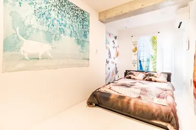 a bedroom with a bed and a painting on the wall at TOKYO SKYTREE Cat house \u62bc\u4e0a\u99c5\u5f92\u6b696\u5206 \u6d45\u8349 in Tokyo