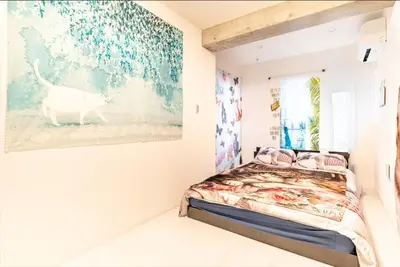 a bedroom with a bed and a painting on the wall at TOKYO SKYTREE Cat house \u62bc\u4e0a\u99c5\u5f92\u6b696\u5206 \u6d45\u8349 in Tokyo