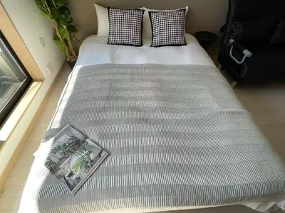 a bed in a room with a magazine on it at COMMA HOUSE Kitaikebukuro 201 in Tokyo