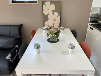 a white table with a vase of flowers on it at COMMA HOUSE Kitaikebukuro 201 in Tokyo