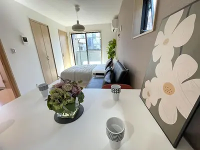 a room with a table with a vase of flowers on it at COMMA HOUSE Kitaikebukuro 201 in Tokyo