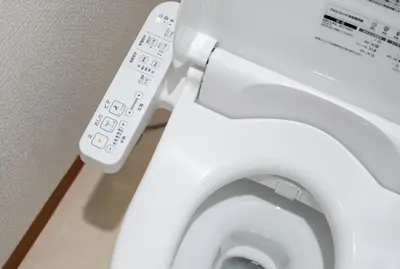 a close up of a white toilet with a remote control at OHAYO AN asakusa in Tokyo