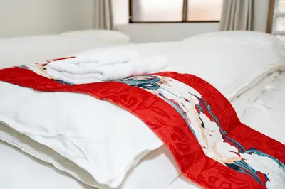 a red and white blanket on a bed at OHAYO AN asakusa in Tokyo