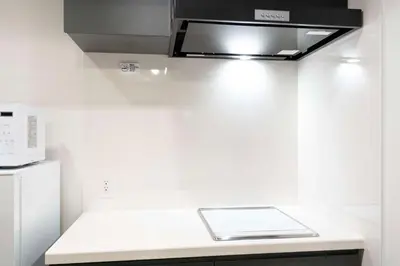 a kitchen with a white counter top with a microwave at ASTiLE\u62bc\u4e0a in Tokyo