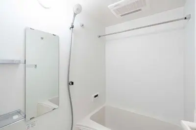 a white bathroom with a sink and a mirror at ASTiLE\u62bc\u4e0a in Tokyo