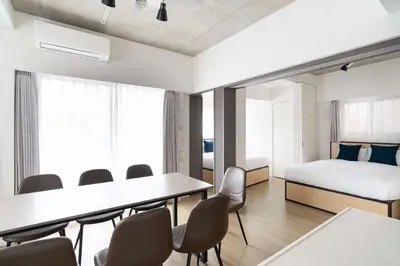 a room with a bed and a table and chairs at ASTiLE\u62bc\u4e0a in Tokyo