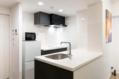 a kitchen with a sink and a refrigerator at ASTiLE\u62bc\u4e0a in Tokyo