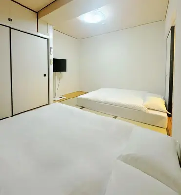 a bedroom with two beds and a window at IKEBUKURO LoveSugamo \u4ea4\u901a\u4fbf\u5229 \u5c71\u624b\u7dda\u5de3\u9d28\u99c5\u5f92\u6b693\u5206 \u6c60\u888b\u99c54\u5206 2\u30fc4\u4eba \u30a8\u30ec\u30d9\u30fc\u30bf\u30fc WIFI \u65b0\u5bbf \u6e0b\u8c37 \u9280\u5ea7 \u6d45\u8349 \u9280\u5ea7 \u539f\u5bbf\u30a2\u30af\u30bb\u30b9\u4fbf\u5229 \u7a7a\u6e2f\u76f4\u901a in Tokyo